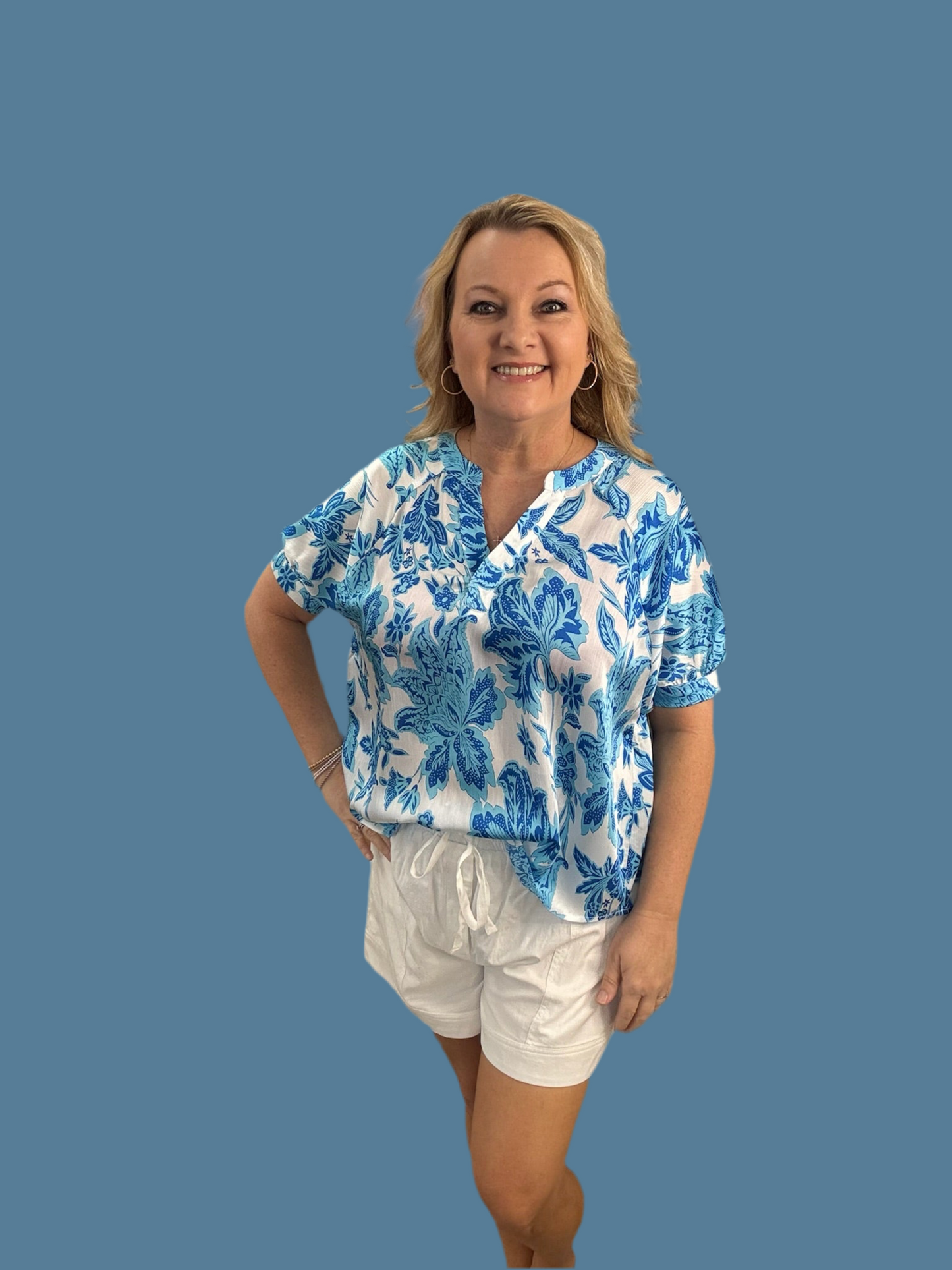 Flower print top with V-neck, back shirring detailing, short dolman sleeves, and band cuff