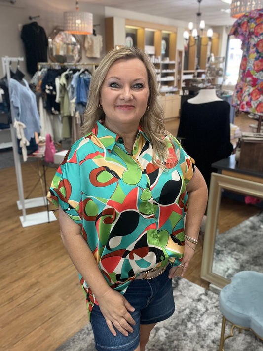 Satin multicolor print top with collared neck, back wrinkle detail, short kimono sleeves, band cuffs, and curved hemline.