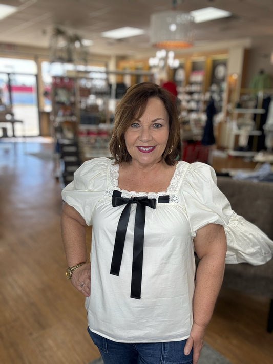 Solid short bubble sleeve pullover top featuring lace finish square neckline with adjustable front satin bow
