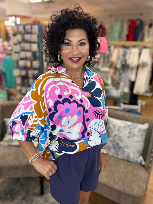 Multicolor print top with open collared neck, half dolman sleeves, and stretch-band cuffs