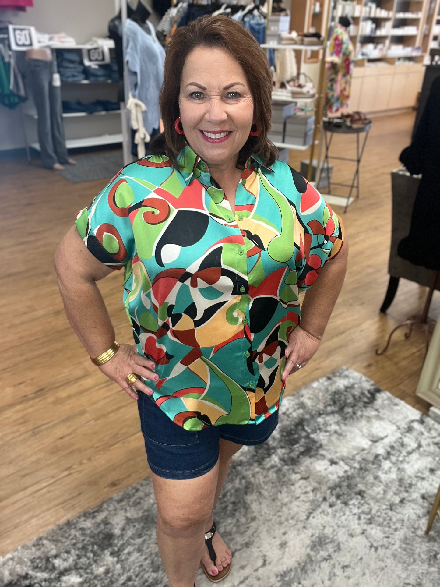 Satin multicolor print top with collared neck, back wrinkle detail, short kimono sleeves, band cuffs, and curved hemline.