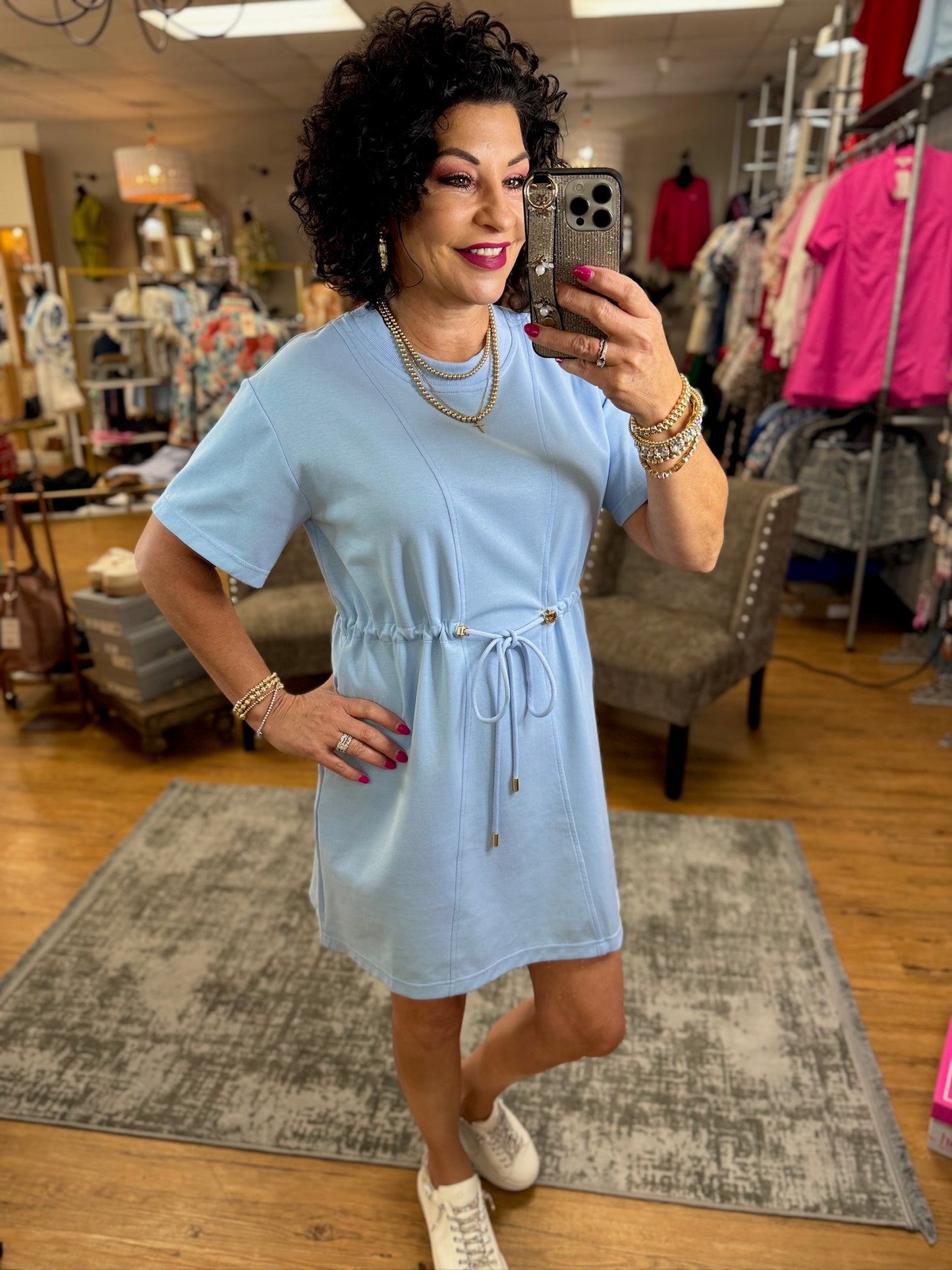 Solid round neck short sleeve mini dress featuring adjustable drawstring at waist. Pocket at sides.