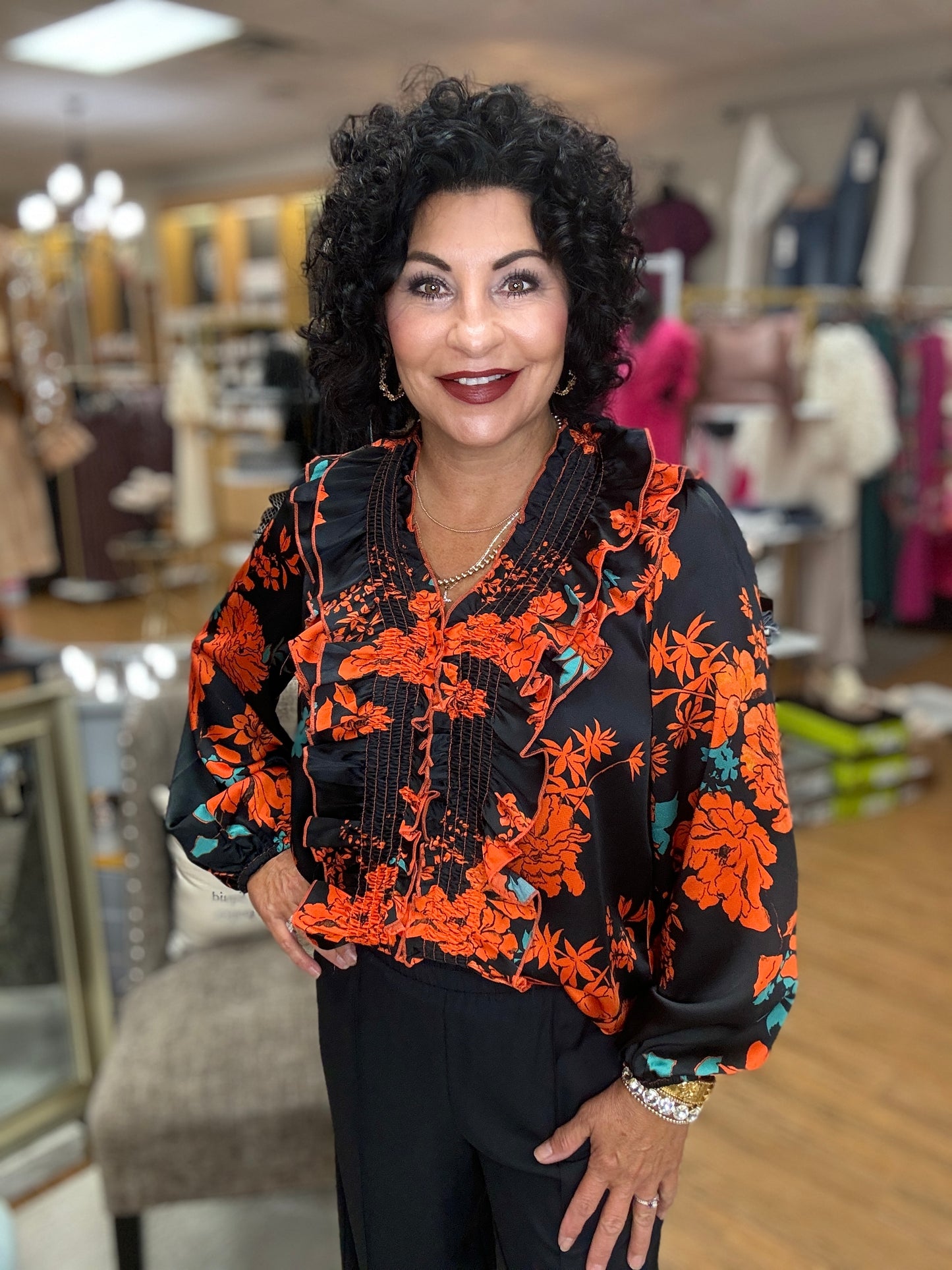 Floral print v-neck long sleeve top featuring smocking and ruffle detail at front and back. Elastic at cuff. Unlined. Woven. Non-sheer. Lightweight.